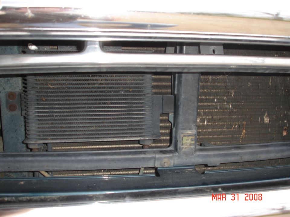 Close-up of vehicle radiator and transmission cooler assembly behind grille