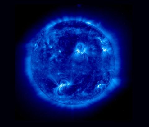 1988 Mercury Grand Marquis - Blue-tinted ultraviolet astronomical image of the Sun showing bright active regions and coronal detail against black space.