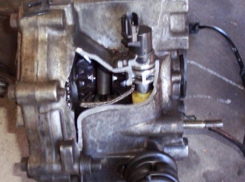 1995 Ford Probe - Close-up of a cracked transmission casing with internal gears and a sensor visible.