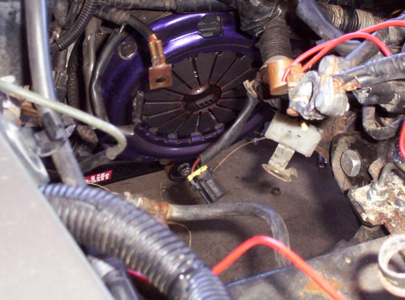 close-up of a purple clutch assembly with wires and hoses