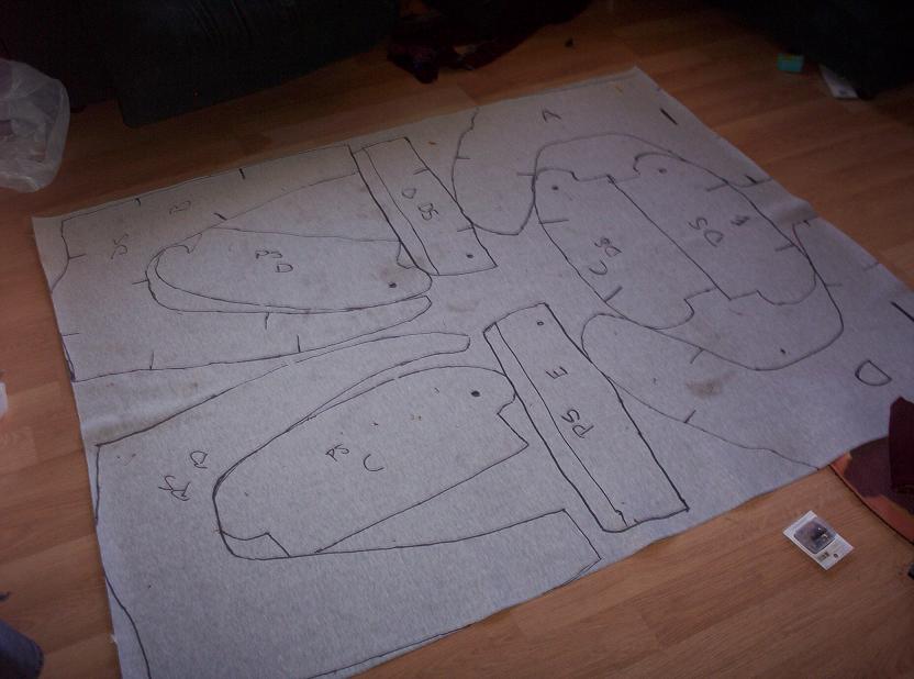 Carpet cutouts with labels like 'DS', 'PS E', 'C', 'D', 'A' on a wooden floor