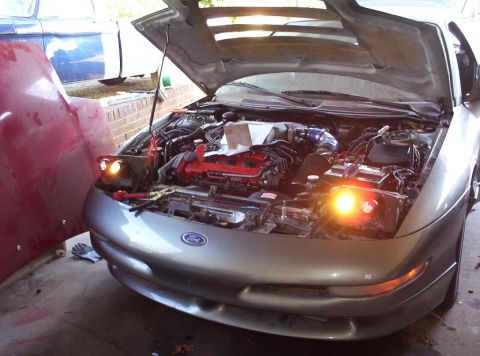 1995 Ford Probe - A silver 1995 Ford Probe is shown with its hood open, revealing the engine, parked next to another vehicle.