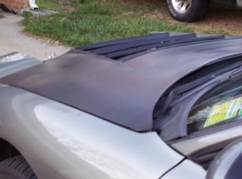 1995 Ford Probe - The hood of a 1995 Ford Probe features black louvers, with another vehicle visible in the background.