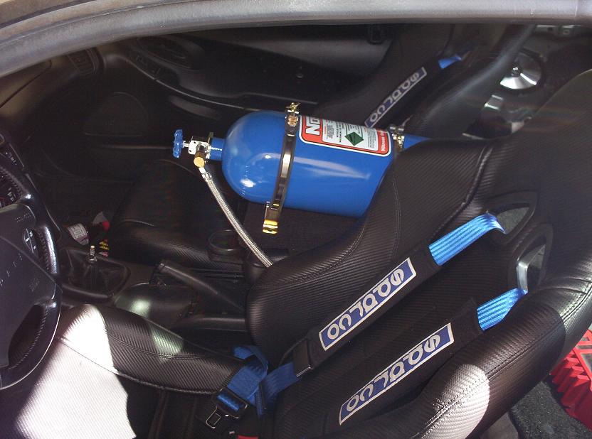 Car interior with racing seats and a blue nitrous oxide tank mounted between them