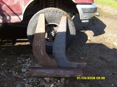 1989 Ford Bronco - Metal winch mount parts are shown next to a vehicle's tire and fender.