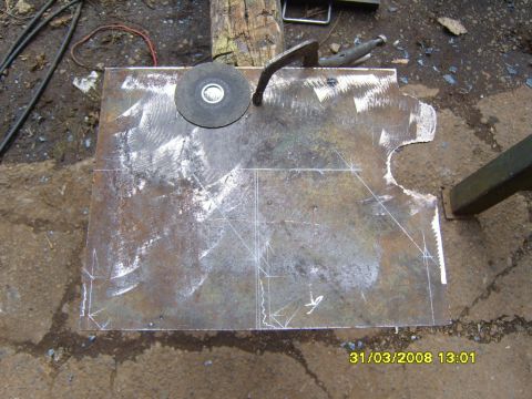 1989 Ford Bronco - A metal plate is prepared for modification with a grinder and clamp, showing layout marks.