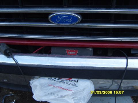 1989 Ford Bronco - The front grille and bumper of a Ford Bronco, showing a WARN winch mounted below the grille.