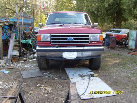 1989 Ford Bronco - Front view of a red 1989 Ford Bronco, showing the grille and 4x4 badging.