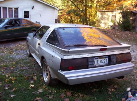 1995 Ford Probe - Rear view of a silver coupe, identified as "CONQUEST TSI" with license plate "1E 8221".