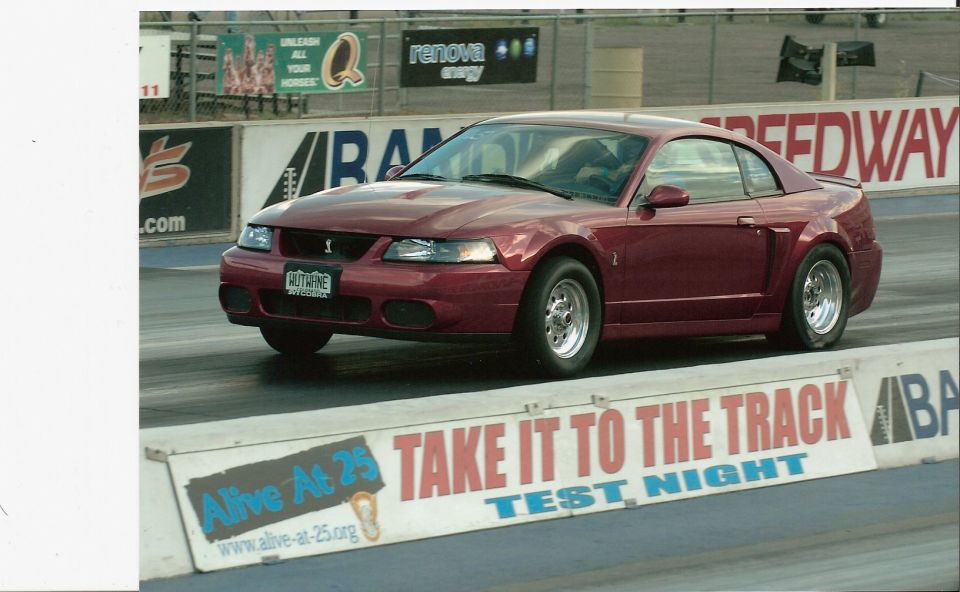 Red 1999 Ford Mustang Cobra with racing slicks on a drag strip