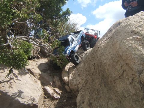1988 Ford Bronco - RC trucks navigate a challenging rocky terrain under a partly cloudy sky.