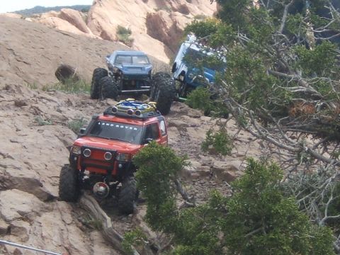1988 Ford Bronco - RC rock crawlers tackle a challenging trail in a desert landscape with rock formations.