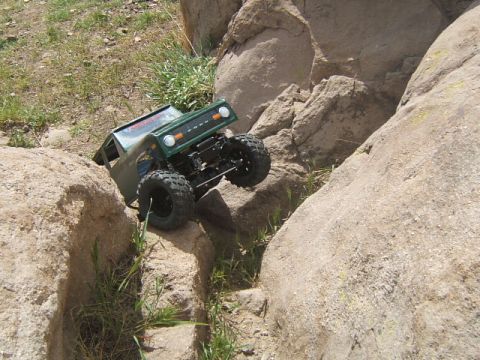 1988 Ford Bronco - RC rock crawler truck navigating a rocky trail.