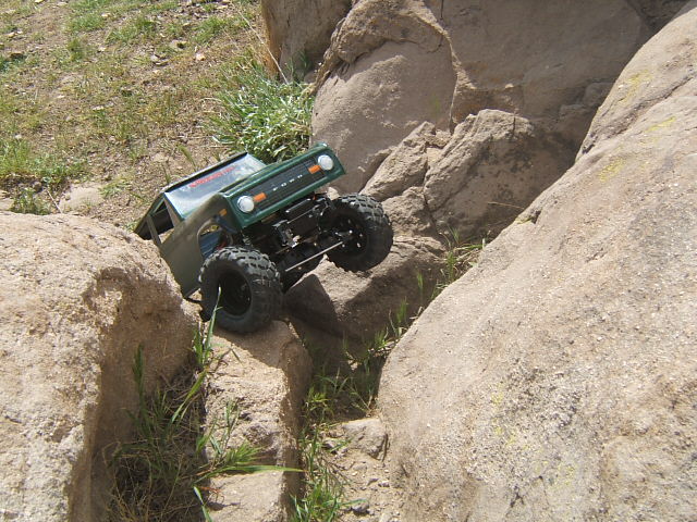 Green RC rock crawler truck with "FORD" grille on rocks