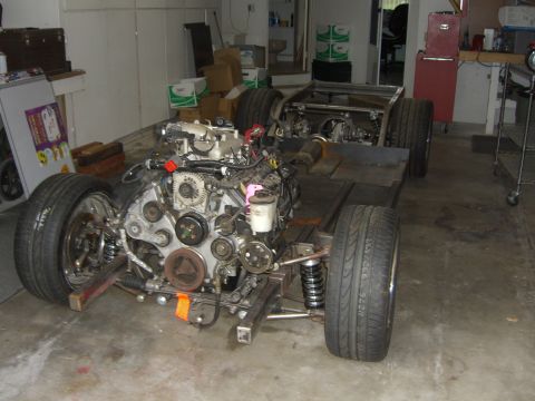 1964 Ford Ranchero - A vehicle's chassis and engine are assembled, ready for further work in a garage setting.