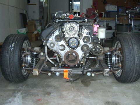 1964 Ford Ranchero - Engine and front suspension assembly with two wheels attached, likely for a custom build.