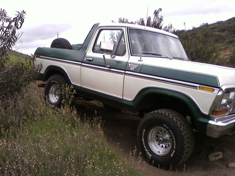 1978 Ford Bronco on a dirt trail with green and white paint