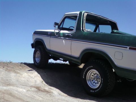 1978 Ford Bronco - This 1978 Ford Bronco is shown from a low angle on a dirt incline under a clear blue sky.