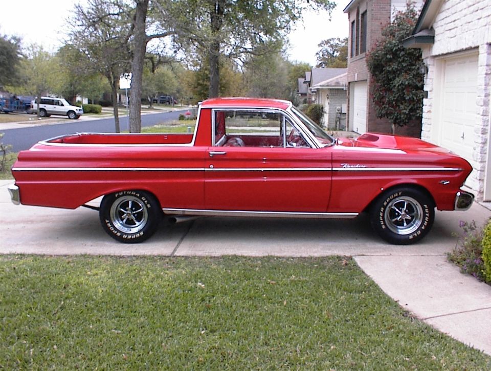 Red Ford Ranchero pickup in side profile on a driveway with chrome wheels