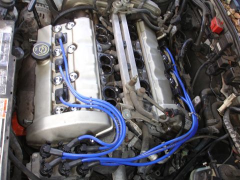 1992 Ford Taurus - Close-up of an engine compartment with prominent blue spark plug wires.
