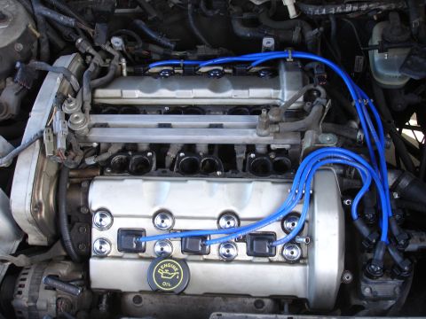 1992 Ford Taurus - Close-up view of a V6 engine bay, showing spark plug wires and engine components.