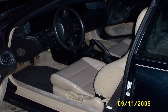 Car interior with tan seats, black dashboard, and steering wheel. A date stamp reads 09/11/2005