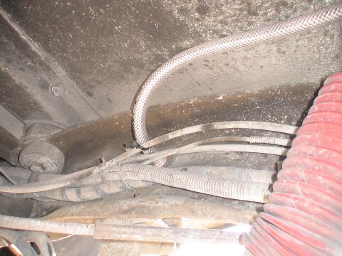 1993 Ford C-350 (Centurion Conversions) - Underside view of a vehicle, revealing various hoses and wiring harnesses secured to the frame.