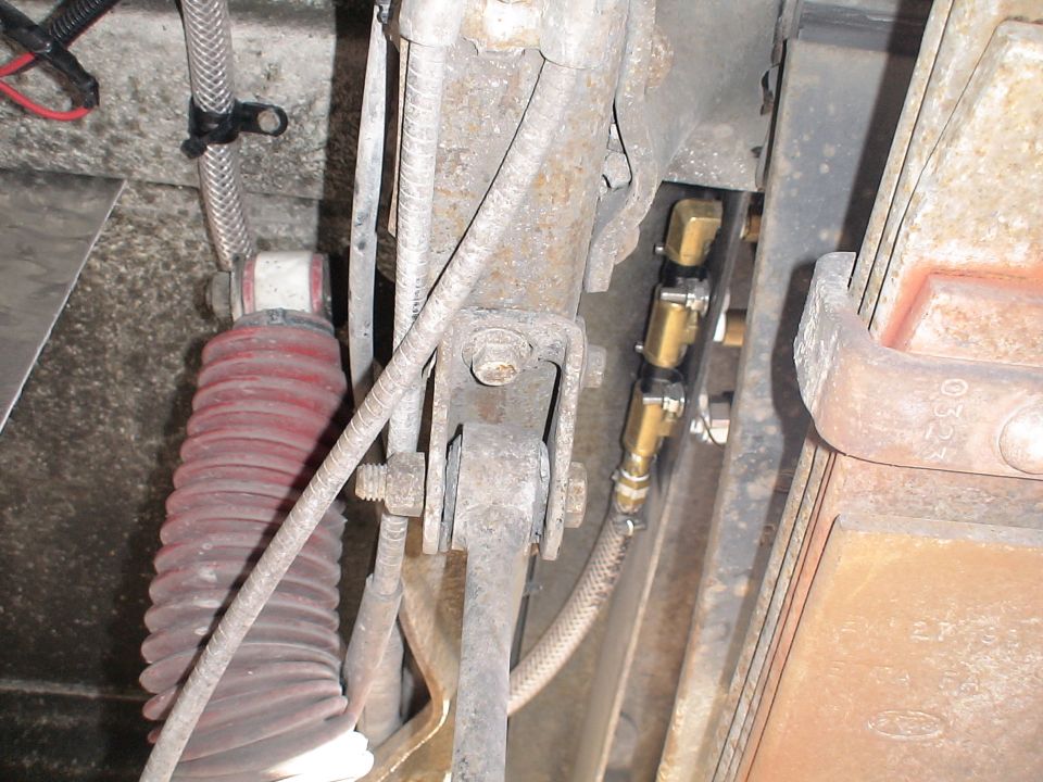 Close-up of vehicle air suspension with red bellows shock absorber and brass fittings