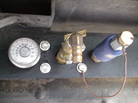 1993 Ford C-350 (Centurion Conversions) - Close-up of an air pressure gauge and a brass valve with a blue fitting attached.