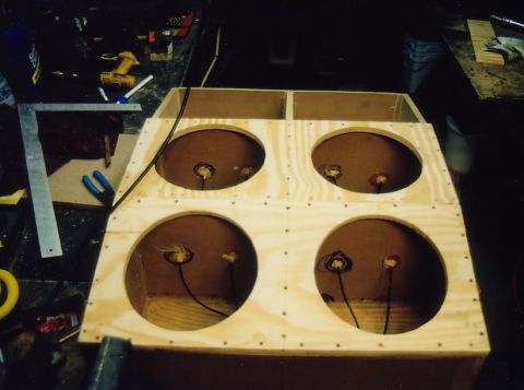 1994 Ford Bronco - A custom-built wooden speaker enclosure with four large circular openings, ready for speaker installation.
