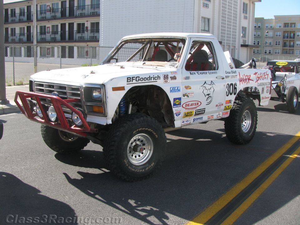 White race-prepped pickup truck number 306 with red tube bumper on a street