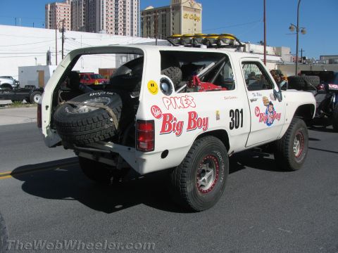 1990 Ford Bronco - Rear three-quarter view of a white off-road race truck numbered 301 with Big Boy graphics and a rear-mounted spare tire.