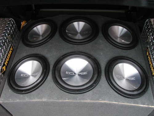 Six round Eclipse car subwoofers mounted in a carpeted box, diamond-plate Husky panels