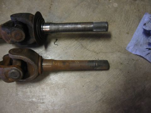 1995 Ford Bronco - Comparison of two drive shafts, one showing significant rust and wear.