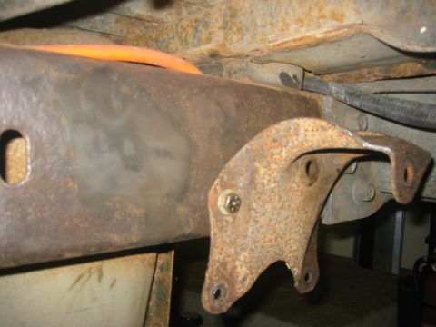 1995 Ford Bronco - Close-up view of a rusted frame bracket and associated chassis parts, with visible screws and wiring.