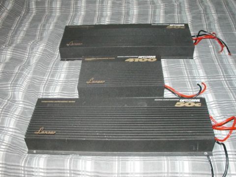 1994 Ford Bronco - Three Lanzar car amplifiers are shown on a plaid surface, with visible wiring on two of them.