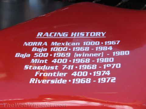 1990 Ford Bronco - Photo of 'Racing History' text painted on a red race vehicle listing NORRA, Baja and Mint 400 results by year.