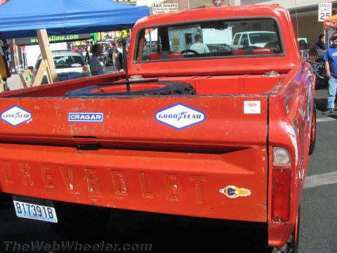 1990 Ford Bronco - dented tailgate of a weathered red Chevrolet pickup carries Goodyear and Cragar decals and an embossed CHEVROLET name.