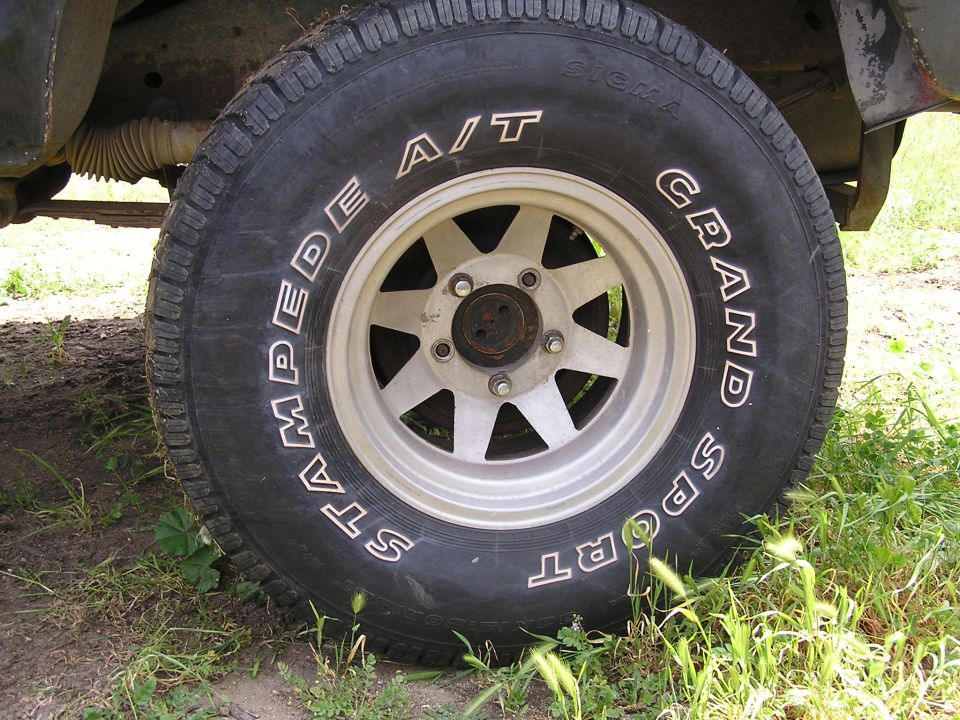 Stampede A/T Grand Sport tire on a seven-spoke alloy wheel on grass