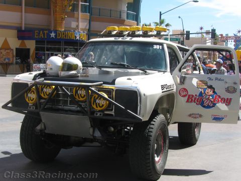 1990 Ford Bronco - white Dodge off-road race truck numbered 301 with a tubular front bumper and yellow lights sits on a street, sporting a Bob's Big Boy decal.