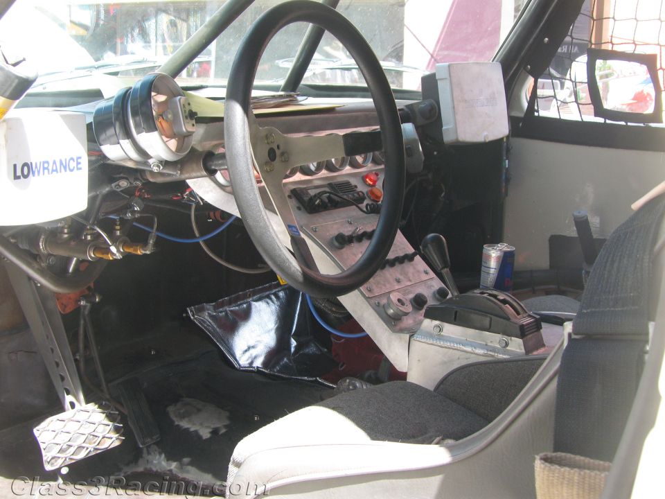 Interior of a race truck showing steering wheel, gauges and Lowrance unit