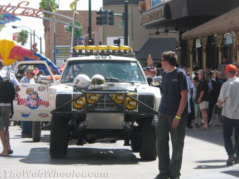 1990 Ford Bronco - white off-road prerunner truck #361 with stacked roof lights and brush guard parked on a crowded Fremont Street in Las Vegas.