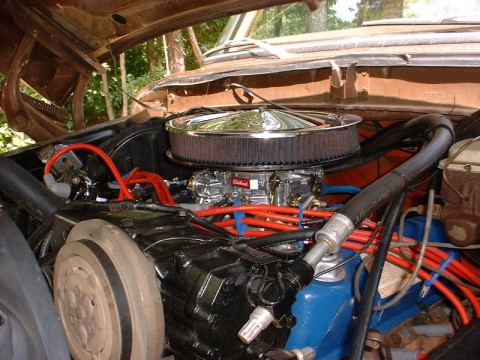 1978 Ford Bronco - Close-up view of a vehicle's engine bay, a chrome air cleaner and prominent red spark plug wires.