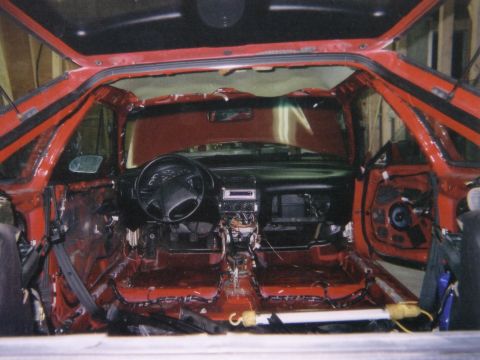 1993 Ford Probe - The interior of a red 1993 Ford Probe is shown with its doors open and interior stripped bare for modification.