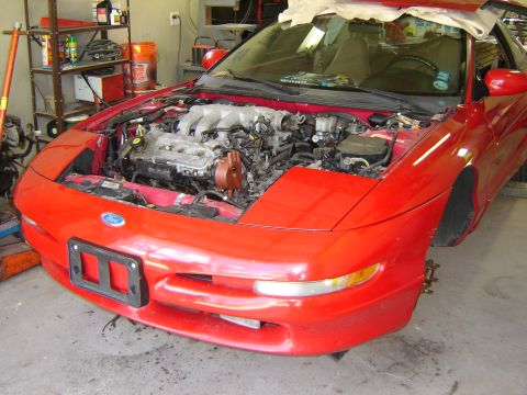 1993 Ford Probe - A red 1993 Ford Probe is shown with its hood open, revealing the engine compartment.