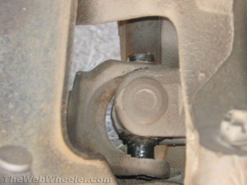 Close-up of a steering shaft universal joint under a vehicle dash
