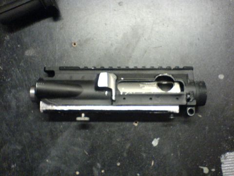 1985 Ford Bronco - AR-15 upper receiver part shown on a dark surface.