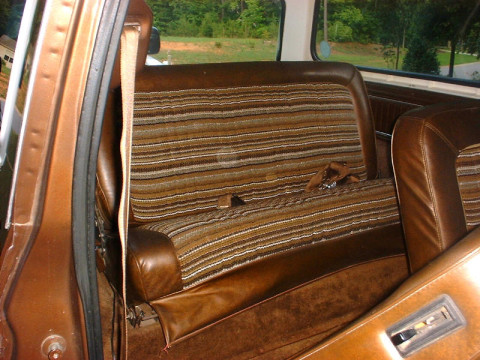 1978 Ford Bronco - The striped fabric and brown leather interior of a 1978 Ford Bronco, viewed from the passenger side door.