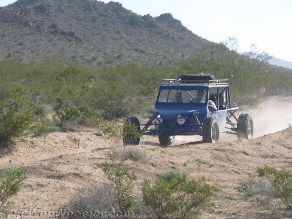 Blue off-road buggy with roof rack driving in the desert