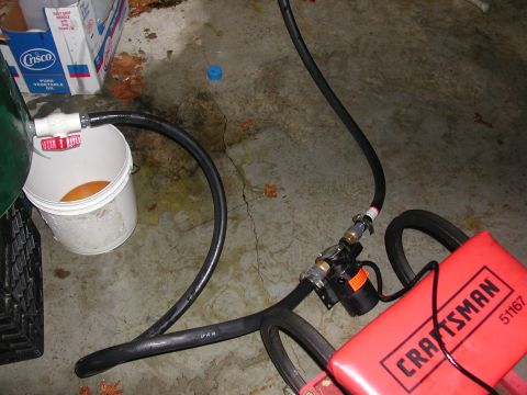 1999 Ford F-250 - A pump and hoses are connected to a bucket, with a Craftsman tool in the foreground.